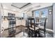 Modern kitchen with stainless steel appliances, breakfast table, and sleek black tiled floors and views at 7 Elgin Pl # 202, Dunedin, FL 34698