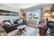 Cozy living room with a leather couch, area rug, desk, and a large window with a view at 7 Elgin Pl # 202, Dunedin, FL 34698
