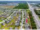 Aerial view of a residential neighborhood with well-maintained lawns and modern homes along a busy road at 7034 Emerald Spring Loop, New Port Richey, FL 34653