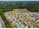 Aerial view of a neighborhood with cozy homes surrounded by lush greenery and nearby wooded areas at 7034 Emerald Spring Loop, New Port Richey, FL 34653