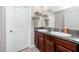 Bathroom featuring a double sink vanity with elegant granite countertops, and ample storage at 7034 Emerald Spring Loop, New Port Richey, FL 34653