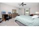 Bedroom featuring a ceiling fan, desk, dresser, and a comfortable bed at 7034 Emerald Spring Loop, New Port Richey, FL 34653