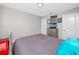 Comfortable bedroom with gray bedding and wall decor, enhanced by natural light and two doors at 7034 Emerald Spring Loop, New Port Richey, FL 34653