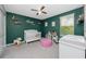 Bright Bedroom with a crib, ceiling fan, changing table, and green walls creating a calming space at 7034 Emerald Spring Loop, New Port Richey, FL 34653