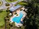 Overhead view of community pool featuring a unique shape, surrounded by lounge chairs and landscaped grounds at 7034 Emerald Spring Loop, New Port Richey, FL 34653