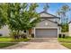 Charming home featuring a well-manicured lawn and a two-car garage, creating a welcoming curb appeal at 7034 Emerald Spring Loop, New Port Richey, FL 34653