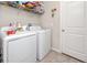 Functional laundry room featuring a white washer, dryer, and storage shelves at 7034 Emerald Spring Loop, New Port Richey, FL 34653