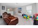 Cozy upstairs living room features plush seating and a large window for natural light at 7034 Emerald Spring Loop, New Port Richey, FL 34653