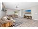 Spacious living room with tile floors, neutral walls, and a cozy sectional couch at 7034 Emerald Spring Loop, New Port Richey, FL 34653