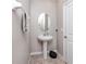Cozy powder room featuring a pedestal sink, oval mirror, and neutral wall color at 7034 Emerald Spring Loop, New Port Richey, FL 34653