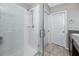 Shower featuring white tile, glass door, and modern fixtures in renovated bathroom at 7034 Emerald Spring Loop, New Port Richey, FL 34653