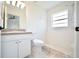 Bright bathroom featuring a shower with white tile, a window, and a single vanity at 7551 52Nd N St, Pinellas Park, FL 33781