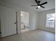 Bright bedroom featuring a ceiling fan, window, and ensuite bathroom access at 7551 52Nd N St, Pinellas Park, FL 33781
