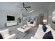 Open-concept living room with a modern ceiling fan and white couches and kitchen at 7551 52Nd N St, Pinellas Park, FL 33781