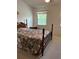 Bedroom featuring a wooden bed frame, and window with patterned curtains at 7616 Colonial Ct, Tampa, FL 33615