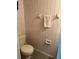 Well-kept half-bathroom with floral wallpaper, toilet, and towel rack at 7616 Colonial Ct, Tampa, FL 33615