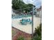 Community pool with an adjacent picnic table, surrounded by a fence at 7616 Colonial Ct, Tampa, FL 33615