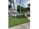 Community pool with a fenced area, surrounded by palm trees and lush greenery at 7616 Colonial Ct, Tampa, FL 33615