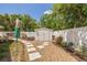 Backyard with white privacy fence, gravel, stone path to shed, lush landscaping and plants at 941 65Th S St, St Petersburg, FL 33707