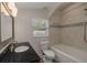 Well-lit bathroom featuring a black granite countertop, bathtub and tiled shower with an arched window at 941 65Th S St, St Petersburg, FL 33707