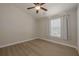 Bedroom with light wood floors, a ceiling fan, and a window with white curtains at 941 65Th S St, St Petersburg, FL 33707