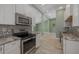 Well-equipped kitchen with stainless steel appliances, granite countertops, stylish backsplash, and white cabinetry at 941 65Th S St, St Petersburg, FL 33707
