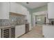 Modern kitchenette featuring white cabinets, stainless steel appliances, and stylish backsplash at 941 65Th S St, St Petersburg, FL 33707