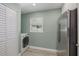 Convenient laundry area with a stainless steel refrigerator, laundry machine and a window at 941 65Th S St, St Petersburg, FL 33707