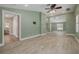A spacious living room with wood-look flooring, light green walls, and recessed lighting at 941 65Th S St, St Petersburg, FL 33707