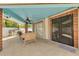 Covered patio with ceiling fan, brick columns, tiled floor, and comfortable wicker seating area at 941 65Th S St, St Petersburg, FL 33707