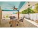 Outdoor covered patio with light blue ceiling, ceiling fan, and wicker outdoor furniture at 941 65Th S St, St Petersburg, FL 33707