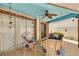 Covered patio with blue ceiling, ceiling fan, sliding glass doors, brick columns, and wicker furniture at 941 65Th S St, St Petersburg, FL 33707