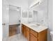 Bathroom with double sinks, wood cabinets and direct access to the main bedroom at 10255 Devonshire Lake Dr, Tampa, FL 33647
