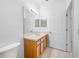 Well-lit bathroom with a toilet, vanity and mirror, and white doors at 10255 Devonshire Lake Dr, Tampa, FL 33647