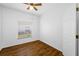 This bedroom has wood-look floors, a ceiling fan, and a window for natural light at 10255 Devonshire Lake Dr, Tampa, FL 33647