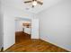 Bedroom with wood-look floors and open doors to another room with a kitchen at 10255 Devonshire Lake Dr, Tampa, FL 33647
