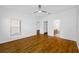 Bedroom with wood-look floors and open doors to another room and a bathroom at 10255 Devonshire Lake Dr, Tampa, FL 33647