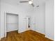 Bright bedroom with a ceiling fan, wood-look floors, open closet, and neutral paint at 10255 Devonshire Lake Dr, Tampa, FL 33647