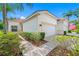 Charming home exterior with a two-car garage, well-manicured landscaping, and an inviting facade at 10255 Devonshire Lake Dr, Tampa, FL 33647