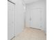 Neutral hallway with tiled floor leading to a white front door at 10255 Devonshire Lake Dr, Tampa, FL 33647