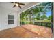 Spacious screened lanai features a ceiling fan, tiled floor, and peaceful views at 10255 Devonshire Lake Dr, Tampa, FL 33647