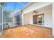 Screened lanai with ceiling fan and tile flooring provides access to the backyard and home interior at 10255 Devonshire Lake Dr, Tampa, FL 33647