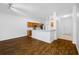 Open living area showcasing beautiful wood floors and a breakfast bar with kitchen views at 10255 Devonshire Lake Dr, Tampa, FL 33647