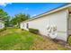 Side yard with well-maintained lawn and tidy landscaping, including the home's exterior utilities at 10255 Devonshire Lake Dr, Tampa, FL 33647