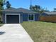 Blue home with a detached garage, sliding glass door, and a driveway at 1108 11Th S Ave, St Petersburg, FL 33705