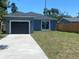 Blue home with detached garage, sliding glass door, and a long driveway at 1108 11Th S Ave, St Petersburg, FL 33705