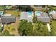 Aerial view of the home featuring a swimming pool, mature landscaping, and a fenced backyard at 11110 105Th Ave, Largo, FL 33778