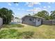 Spacious backyard with lush green grass, fencing, and a view of the screened-in pool at 11110 105Th Ave, Largo, FL 33778