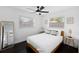 Bright bedroom features a ceiling fan, dark wood floors, and natural light from two windows at 11110 105Th Ave, Largo, FL 33778