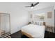 Bright bedroom features a ceiling fan, dark wood floors, and natural light from a window at 11110 105Th Ave, Largo, FL 33778